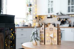 Schlüssel und winzig Haus von ein klein Größe auf gemütlich Zuhause mit Weihnachten Dekor auf Tabelle von festlich Weiß Küche. Geschenk zum Neu Jahr. Versicherung, ziehen um zu Neu Haus, Hypothek, Miete und Kauf echt Nachlass foto