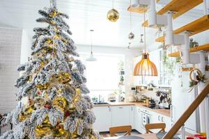 festlich Weihnachten Dekor im Weiß Küche, modern rustikal Innere mit ein schneebedeckt Weihnachten Baum und Fee Beleuchtung. Neu Jahr, Weihnachten Stimmung, gemütlich heim. das Allgemeines planen foto