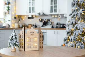 gemütlich Weihnachten Dekor winzig Haus von klein Größe auf Tabelle von festlich Weiß modern Küche. Geschenk zum Neu Jahr. Versicherung, ziehen um zu Neu Haus, Hypothek, Miete und Kauf echt Nachlass foto