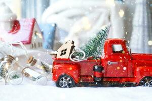 Rotes Retro-Auto mit einem Weihnachtsbaum schmückt mit dem Hausschlüssel im Pickup-Truck zu Weihnachten. Hauskauf, Umzug, Hypothek, Darlehen, Immobilien, Feststimmung, Neujahr foto