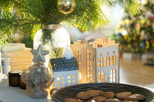 festliche weihnachtsdekoration am tisch, hausgemachte kuchen zum frühstück, bäckereikekse. gemütliches Zuhause, Weihnachtsbaum mit Lichterketten. neujahr, weihnachtsstimmung foto