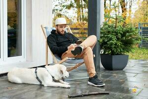 jung Mann Sitzung mit Hund auf Terrasse foto