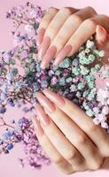 weiblich Hände mit Rosa Nagel Design halt Gypsophila Blumen. foto