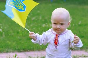 wütend Kind hält ukrainisch Flagge. Mädchen geballt Fäuste im Wut. Vertrauen im gewinnen Krieg. Unabhängigkeit Tag von Ukraine. Flagge Tag. foto