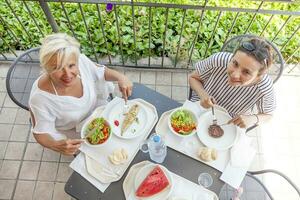 modern Mama und jung Tochter Essen Mittagessen foto