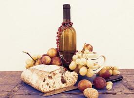 Brot Trauben und ein Flasche von Wein Über hölzern Bretter foto