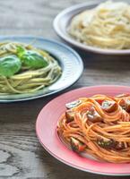 Portionen von bunt Spaghetti mit Zutaten foto