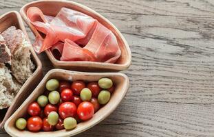 Jamon mit Vorspeisen auf das hölzern Hintergrund foto