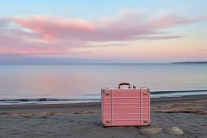 ai generiert Seeküste mit Rosa Koffer auf das sandig Strand auf romantisch Sonnenuntergang. Reise auf Urlaub und Tourist Planung Konzept foto