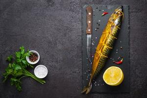 schwarz Essen Hintergrund mit geräuchert Makrele Fisch und Gewürze foto