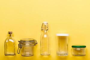 einstellen von Glas Gläser und Flaschen auf Gelb Hintergrund. Null Plastik Konzept foto