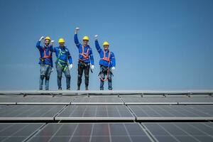 Gruppe von Ingenieure Stehen auf Solar- Paneele mit Blau Himmel im das Hintergrund foto