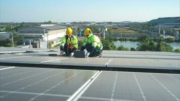 beide von Techniker ist Installation Solar- Paneele auf das Dach von das Warenhaus zu Veränderung Solar- Energie in elektrisch Energie zum verwenden im Fabriken. foto