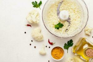 Kochen Blumenkohl Reis Nahansicht und Zutaten auf ein Weiß Hintergrund foto