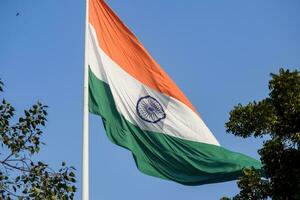 Indien-Flagge, die hoch am Connaught-Platz mit Stolz auf den blauen Himmel fliegt, Indien-Flagge flattert, indische Flagge am Unabhängigkeitstag und Tag der Republik Indien, Schuss nach oben geneigt, indische Flagge schwenkend, Har Ghar Tiranga foto