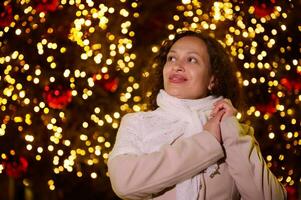 jung schön Frau Gehen im das Stadt unter Nacht Weihnachten Beleuchtung. ziemlich weiblich Tourist Besuch Weihnachten Messegelände foto