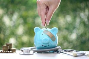 Schweinchen Bank befestigt zu das Gips auf das Kopf und Stethoskop auf Grün Hintergrund, speichern Geld zum medizinisch Versicherung und Gesundheit Pflege Konzept foto