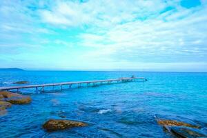 hölzern Seebrücke erstreckt sich zu das Meer.schön tropisch Strand mit Wolken und sky.travel und Ferien foto