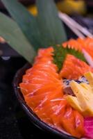 Sashimi einstellen roh Lachs und Thunfisch geschnitten und stellen zusammen im ein schwarz Schüssel. foto