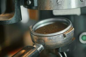 Kaffee Bohnen im ein Siebträger durch das Kaffee Schleifer foto