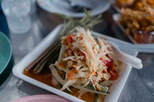 würzig Papaya Salat lecker oder somtum ist ein thailändisch Lebensmittel Dienen auf Schaum Tablett foto