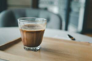 Tasse von heiß Mokka Kaffee auf das Tisch. Kaffee im ein klein Glas Tasse. foto