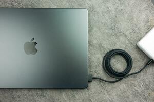 Bangkok, Thailand - - Januar 7, 2024 ein schwarz geflochten USB-C Kabel aufladen und verbinden zu Apfel MacBook Profi mit m3 max foto