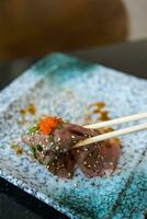 verwenden Essstäbchen Essen roh wagyu Rindfleisch Sushi foto