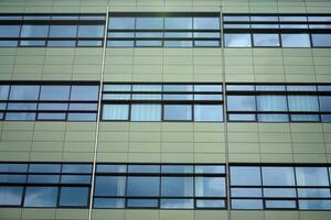 abstrakt Nahansicht von das glasverkleidet Fassade von ein modern Gebäude bedeckt im reflektierend Teller Glas. die Architektur abstrakt Hintergrund. Glas Mauer und Fassade Detail. foto