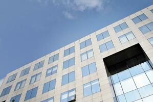 abstrakt Nahansicht von das glasverkleidet Fassade von ein modern Gebäude bedeckt im reflektierend Teller Glas. die Architektur abstrakt Hintergrund. Glas Mauer und Fassade Detail. foto