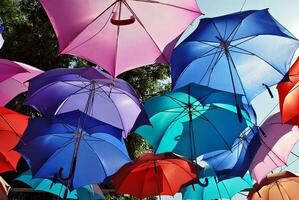 bunt Regenschirme Hintergrund. bunt Regenschirme im das Himmel. Straße Dekoration. foto