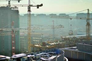 hoch erhebt euch Gebäude unter Konstruktion. Installation von Glas Fassade Paneele auf ein verstärkt Beton Struktur. foto