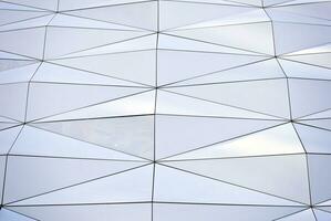 abstrakt Nahansicht von das glasverkleidet Fassade von ein modern Gebäude bedeckt im reflektierend Teller Glas. die Architektur abstrakt Hintergrund. Glas Mauer und Fassade Detail. foto