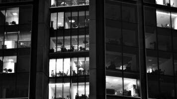 Muster von Büro Gebäude Fenster beleuchtet beim Nacht. Glas die Architektur , Unternehmen Gebäude beim Nacht - - Geschäft Konzept. schwarz und Weiß. foto