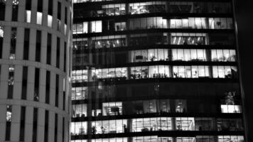 Muster von Büro Gebäude Fenster beleuchtet beim Nacht. Glas die Architektur , Unternehmen Gebäude beim Nacht - - Geschäft Konzept. schwarz und Weiß. foto