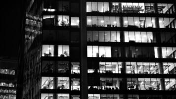 Muster von Büro Gebäude Fenster beleuchtet beim Nacht. Glas die Architektur , Unternehmen Gebäude beim Nacht - - Geschäft Konzept. schwarz und Weiß. foto