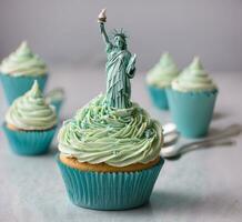 ai generiert Cupcakes mit Statue von Freiheit und Grün Buttercreme Glasur foto