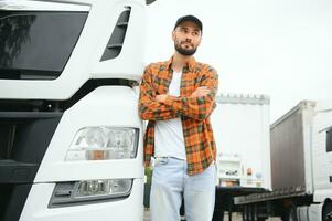 Porträt von jung bärtig Mann Stehen durch seine LKW. Fachmann LKW Treiber Stehen durch halb LKW Fahrzeug. foto