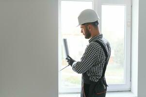 bauarbeiter, der fenster im haus installiert foto