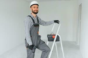 jung Arbeiter Herstellung Reparatur im Zimmer. foto