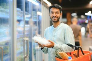 asiatisch Männer sind wählen zu Kaufen im das Supermarkt foto