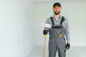 jung Arbeiter Gemälde Mauer im Zimmer. foto