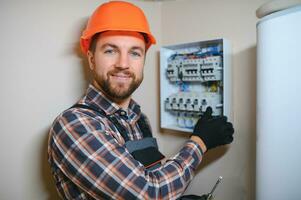 ein männlich Elektriker funktioniert im ein Telefonzentrale mit ein elektrisch verbinden Kabel foto