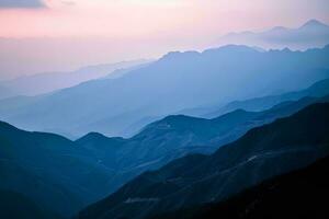 ai generiert ein atemberaubend Aussicht von geschichtet Berge unter ein Gradient Himmel Übergang von Tag zu Nacht, präsentieren der Natur Ruhe noch majestätisch Schönheit foto