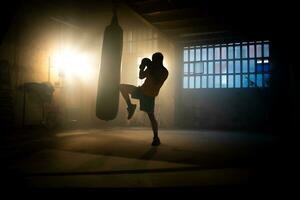 Kickboxen oder kriegerisch Kunst Kämpfer Treffer Stanzen Tasche mit Knie im das Fitnessstudio. foto