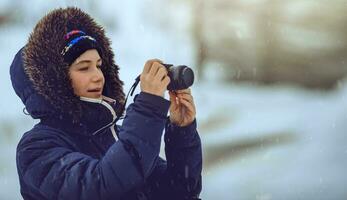 jung weiblich nehmen Bilder im Schneefall foto