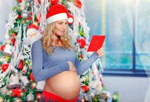 glücklich schwanger Frau im Weihnachten Vorabend foto