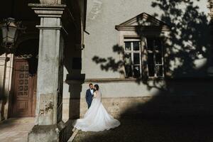 das Braut in der Nähe von das Schloss, ein schick Weiß Kleid, Schatten von das Bäume, ein wichtig historisch Gebäude foto