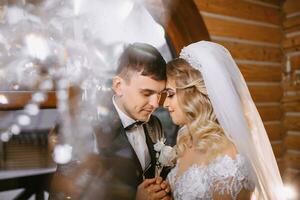 ein schön Braut im ein Hochzeit Kleid mit ein schön Frisur und ein Bräutigam im ein schwarz passen im ein schön hölzern Innere foto