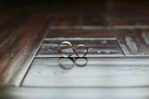 Nahansicht von Hochzeit Ringe im Box auf Tisch. Hochzeit Ringe. zwei golden Hochzeit Ringe im ein hölzern Box auf ein Sanft Kopfkissen. foto